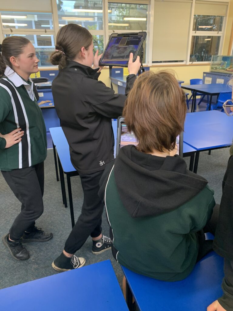 Students using an iPad to test a augmented reality app for mine rehab